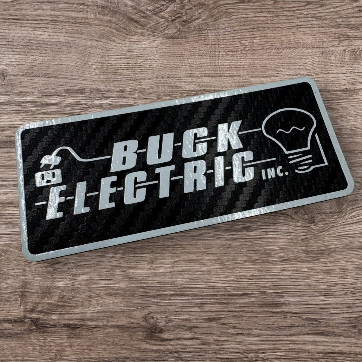 Black and silver rectangular UV printed leatherette logo patch for Buck Electric Inc.