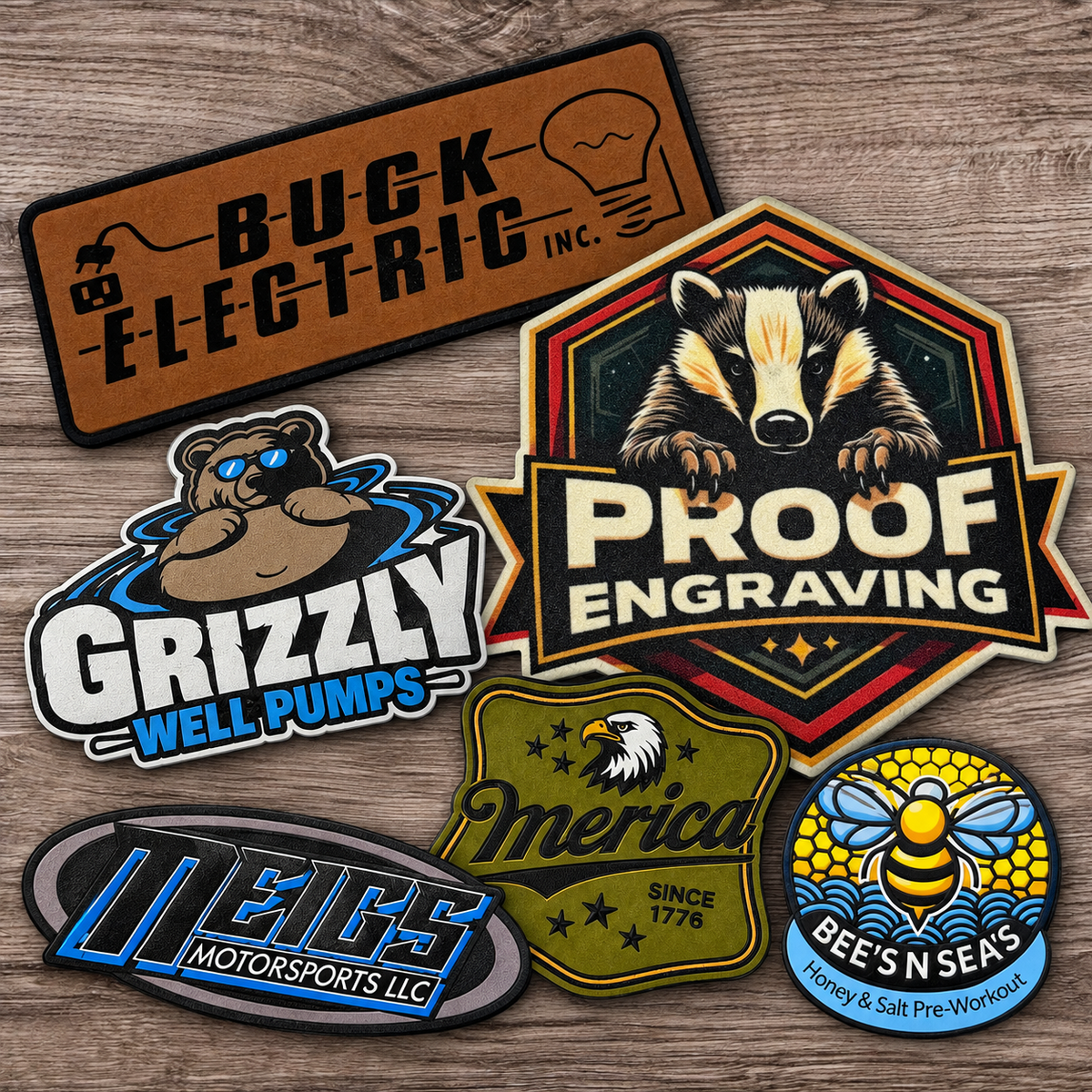 Laser-engraved and full-color UV-printed custom leatherette hat patches arranged on gray wood, featuring business logos and Proof Engraving.